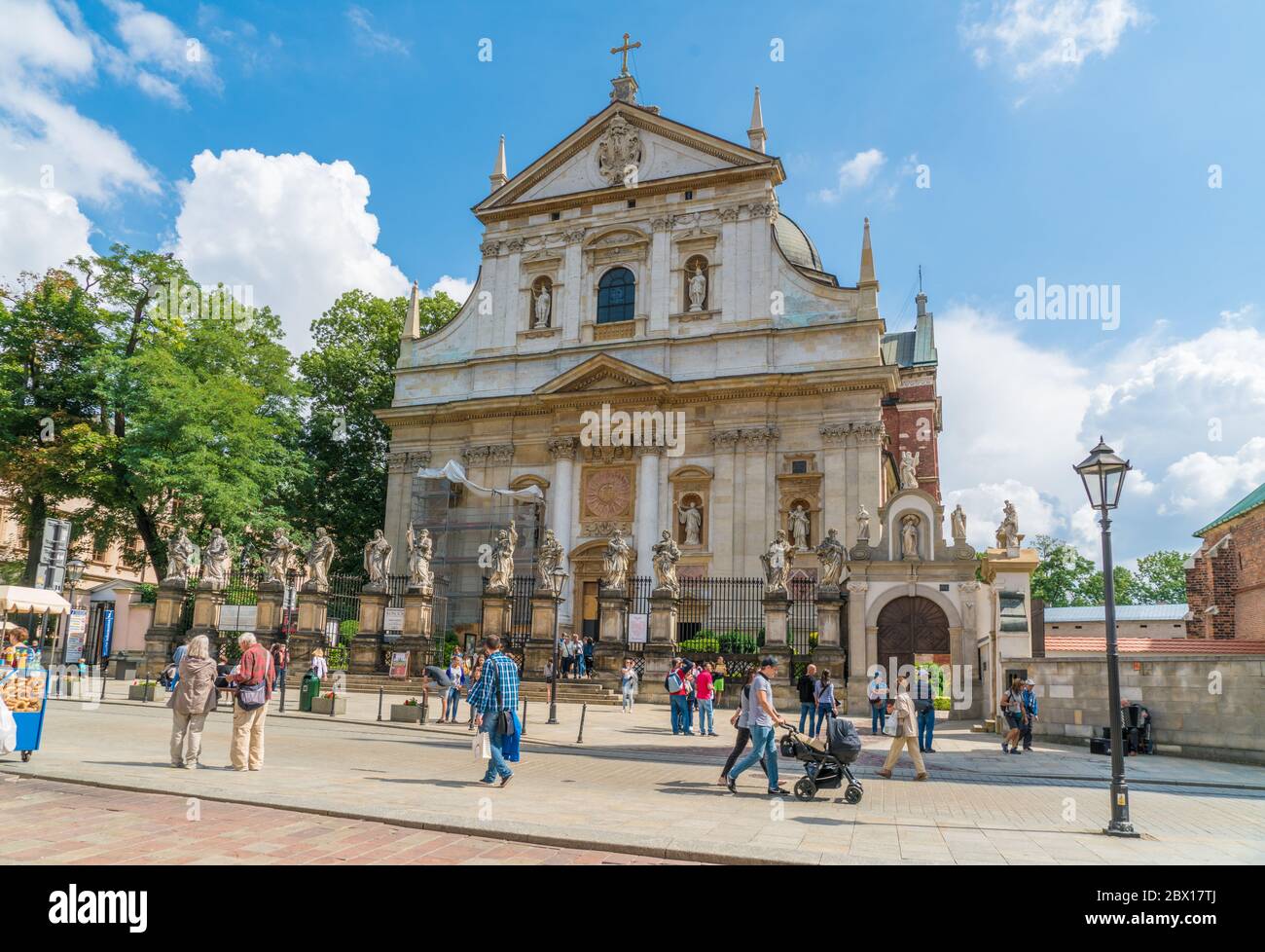 Krakau August 21th 2017: Tourists passing the old church (Kościół Rzymskokatolicki pw. Świętych Apostołów Piotra i Pawła) on Grodzka street in the cen Stock Photo