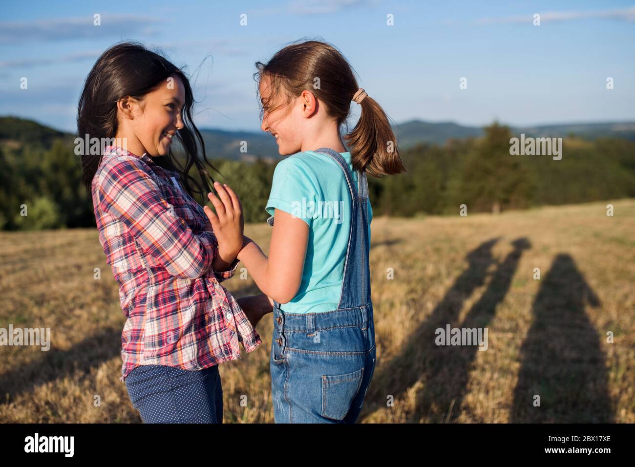 Two school children walking on field trip in nature, playing. Stock Photo