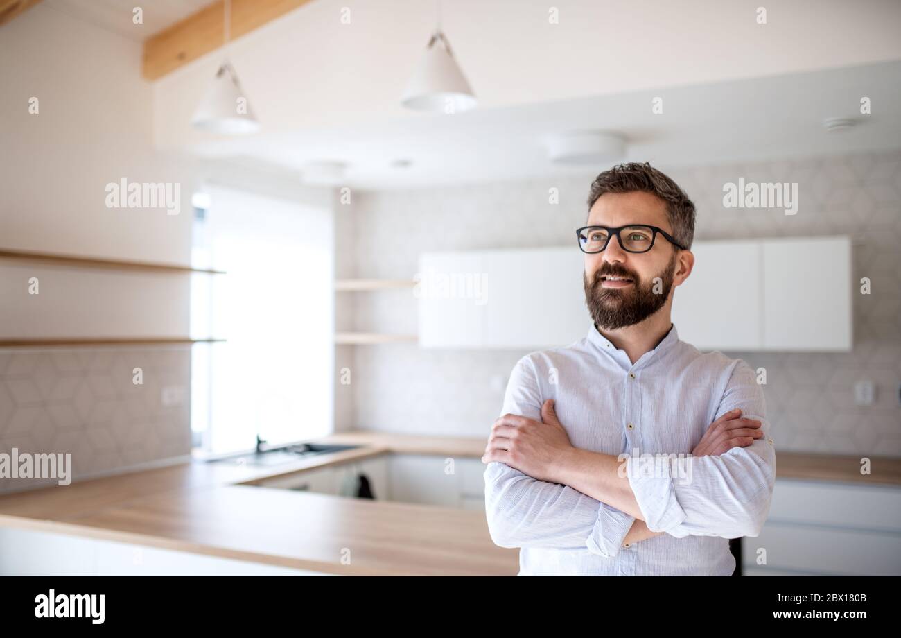 Mature man standing in house, moving in new home concept. Stock Photo
