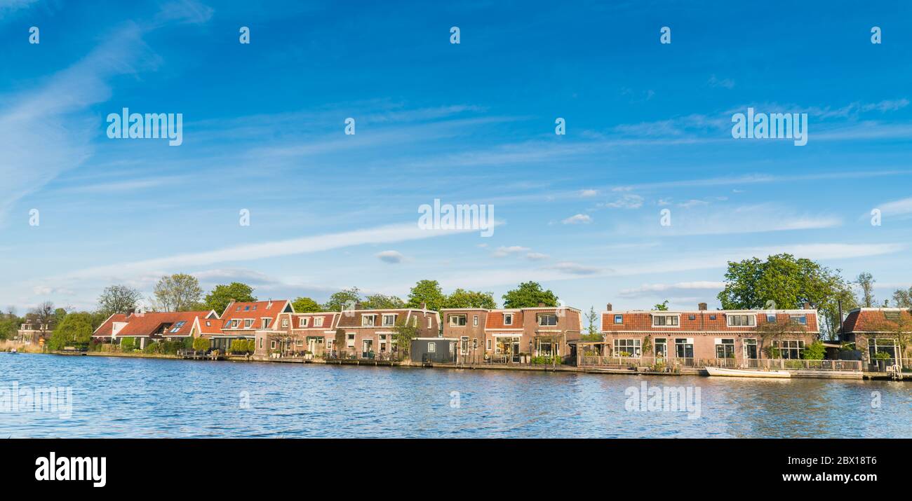 Ouderkerk aan de Amstel, The Netherlands, April 19, 2017: Row of traditional Dutch houses on the riverside of the Amstelriver Stock Photo