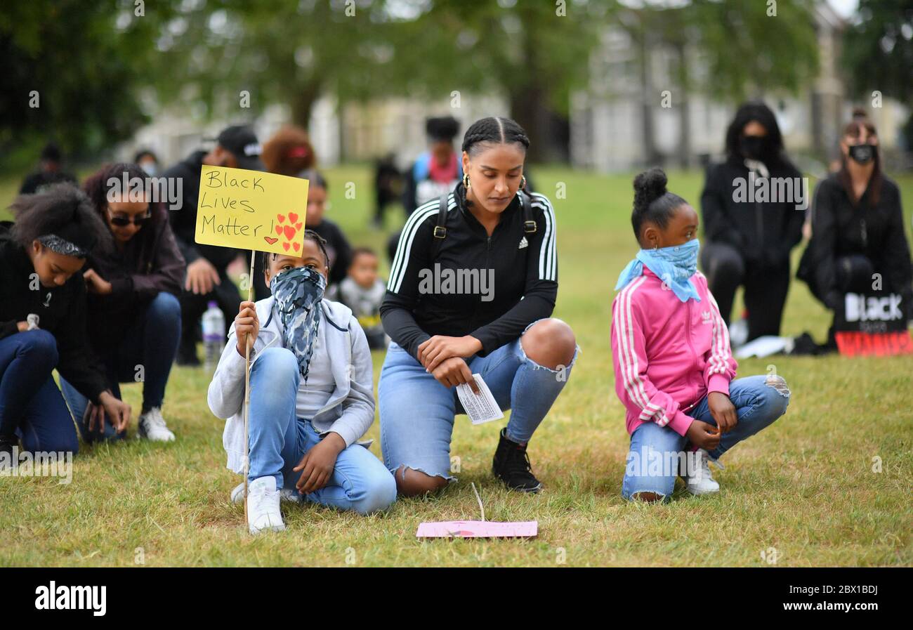 People take a knee for two minutes during a Black Lives Matter protest rally at Eastville Park in Bristol in memory of George Floyd who was killed on May 25 while in police custody in the US city of Minneapolis. Stock Photo