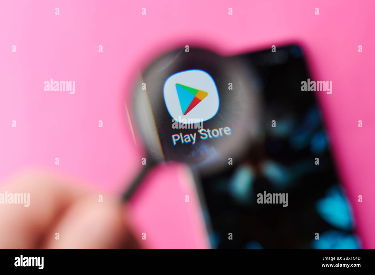 New-York , USA - June 4 , 2020: Browsing Play store app on modern smartphone throw magnifier close up view Stock Photo