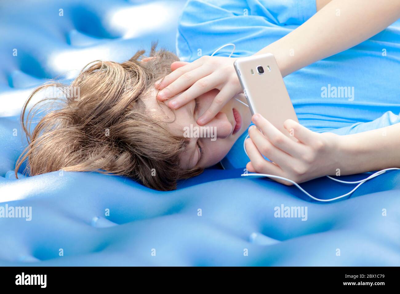 Teenage Boy Watching Movies on Mobile Phone. Stock Photo