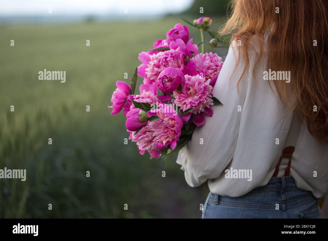 summer - Beautiful girl with a bouquet peony at the field Stock Photo ...