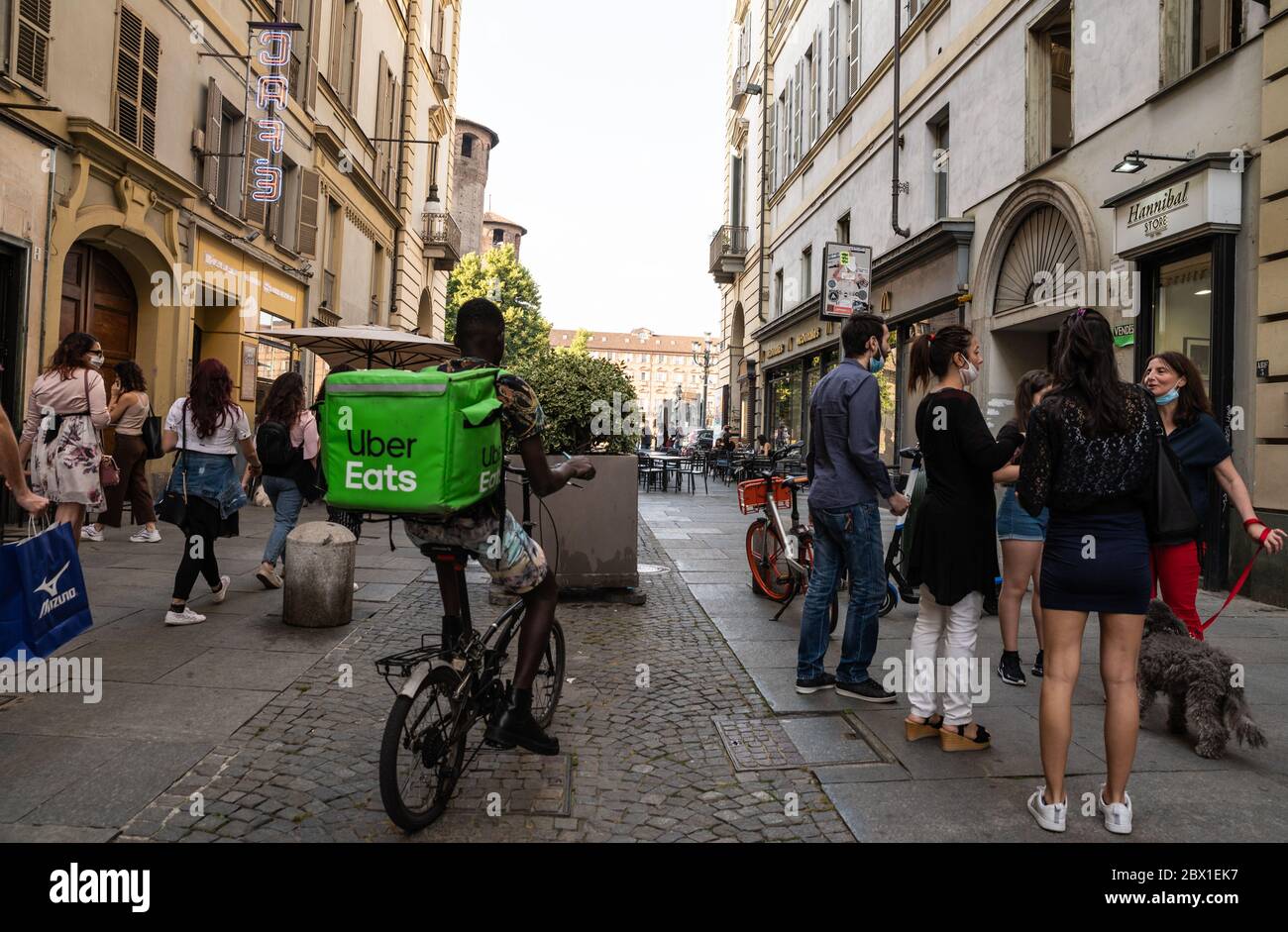 Turin, Piedmont, Italy. May 2020. A worker at Uber Eat, a home delivery company for food and drink. It's easy to notice them: the voluminous cubic tra Stock Photo