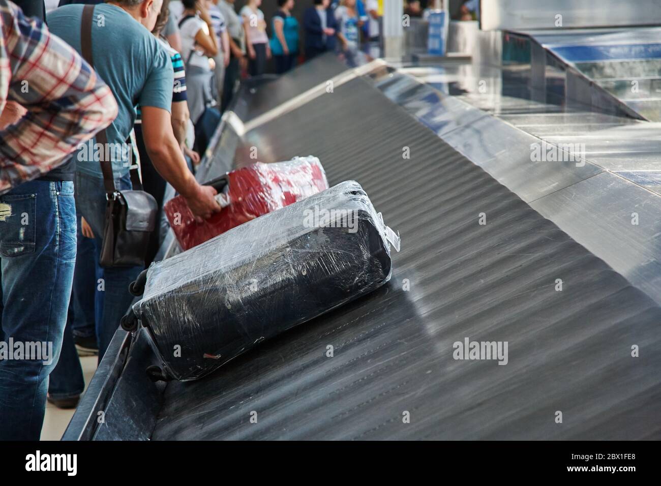 moving conveyor belt with suitcases at baggage claim at airport. Stock Photo