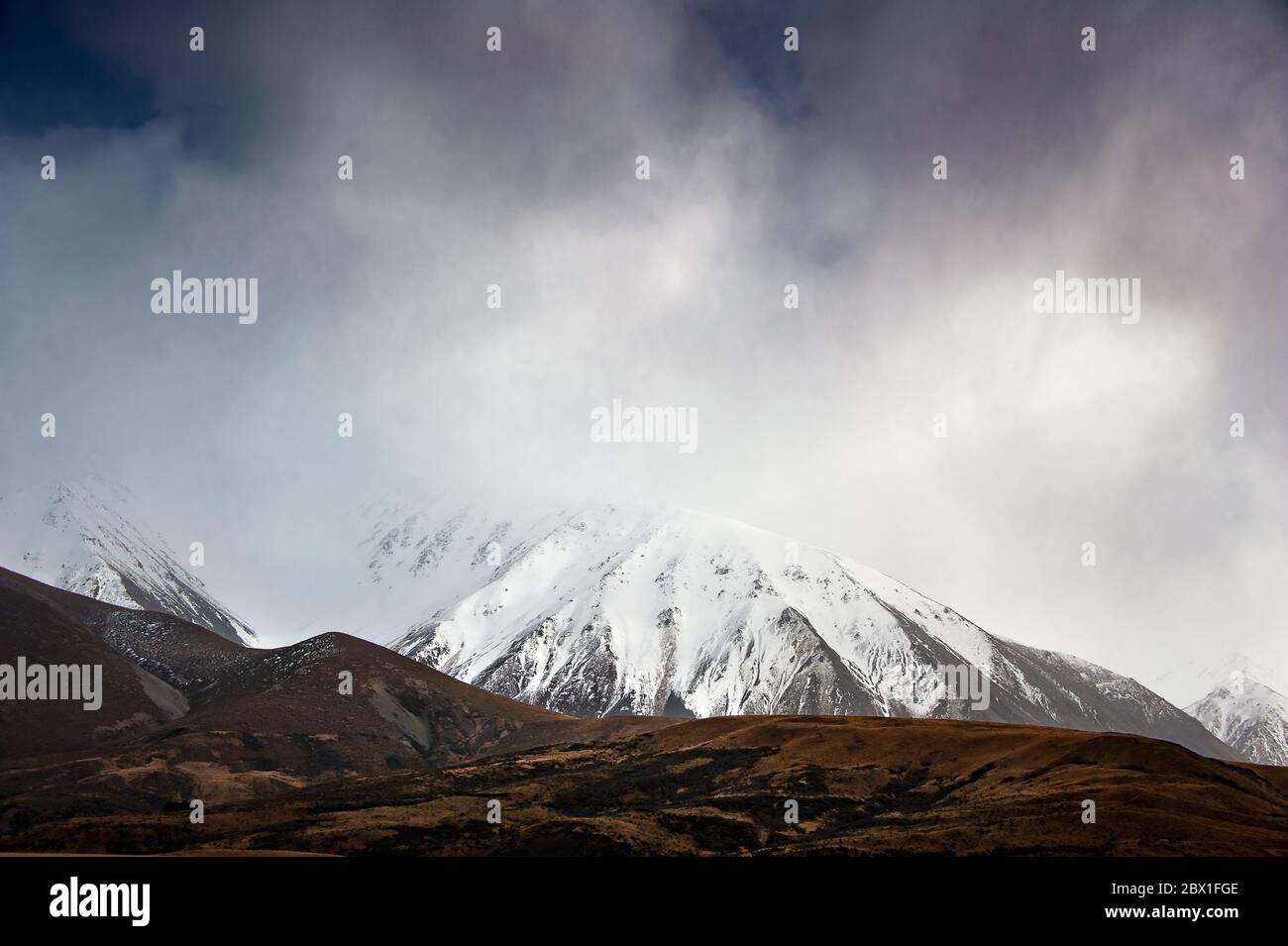 Arthur's Pass, Canterbury Region, New Zealand. Dramatic landscape, snow covered mountain, moody sky. Stock Photo