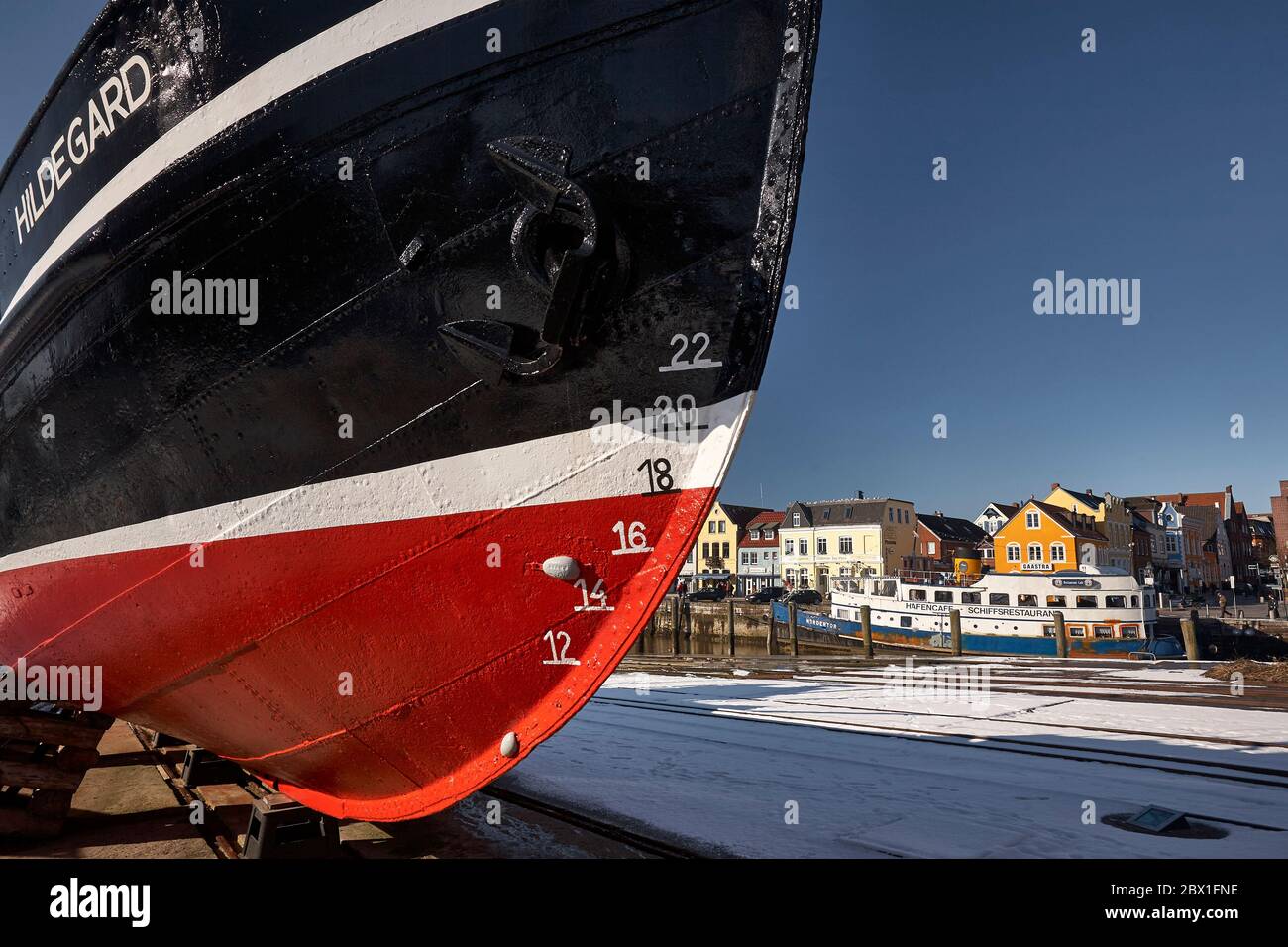 The bow of the fishing cutter Hildegard on he slipway in front of the restaurant ship and café in the Husum harbour. Stock Photo