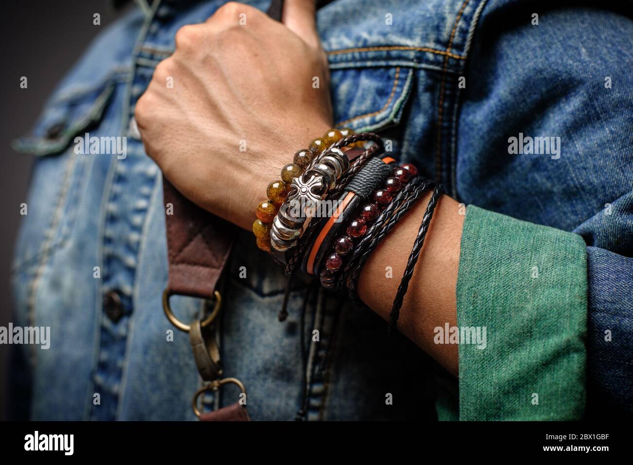 The man in jean jacket wearing bracelets, casual style of men accessories.  Shallow depth of field Stock Photo - Alamy