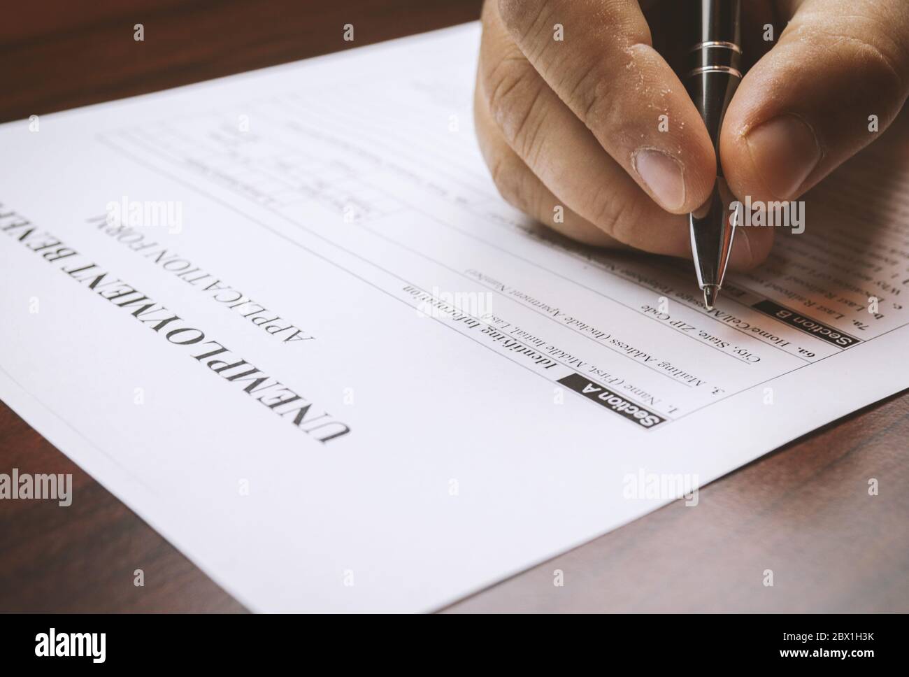 Close-up of a person's hand filing social security benefits application  form. Concept of coronavirus and stay at home order impact on economy.  Select Stock Photo - Alamy