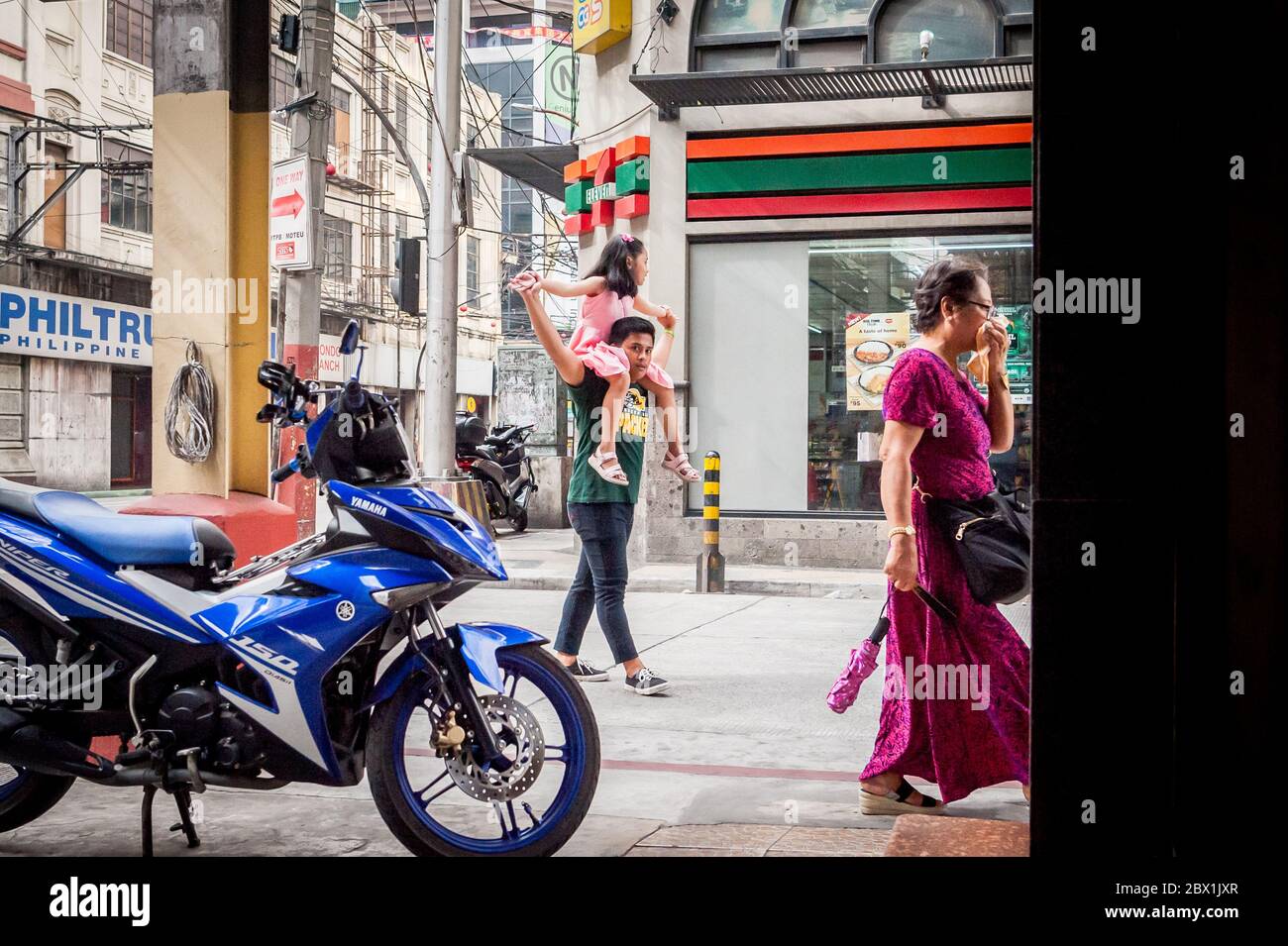 A dad plays with his daughter walking under the  Filipino Friendship Arch in the Binondo District, China Town, Manila, The Philippines. Stock Photo