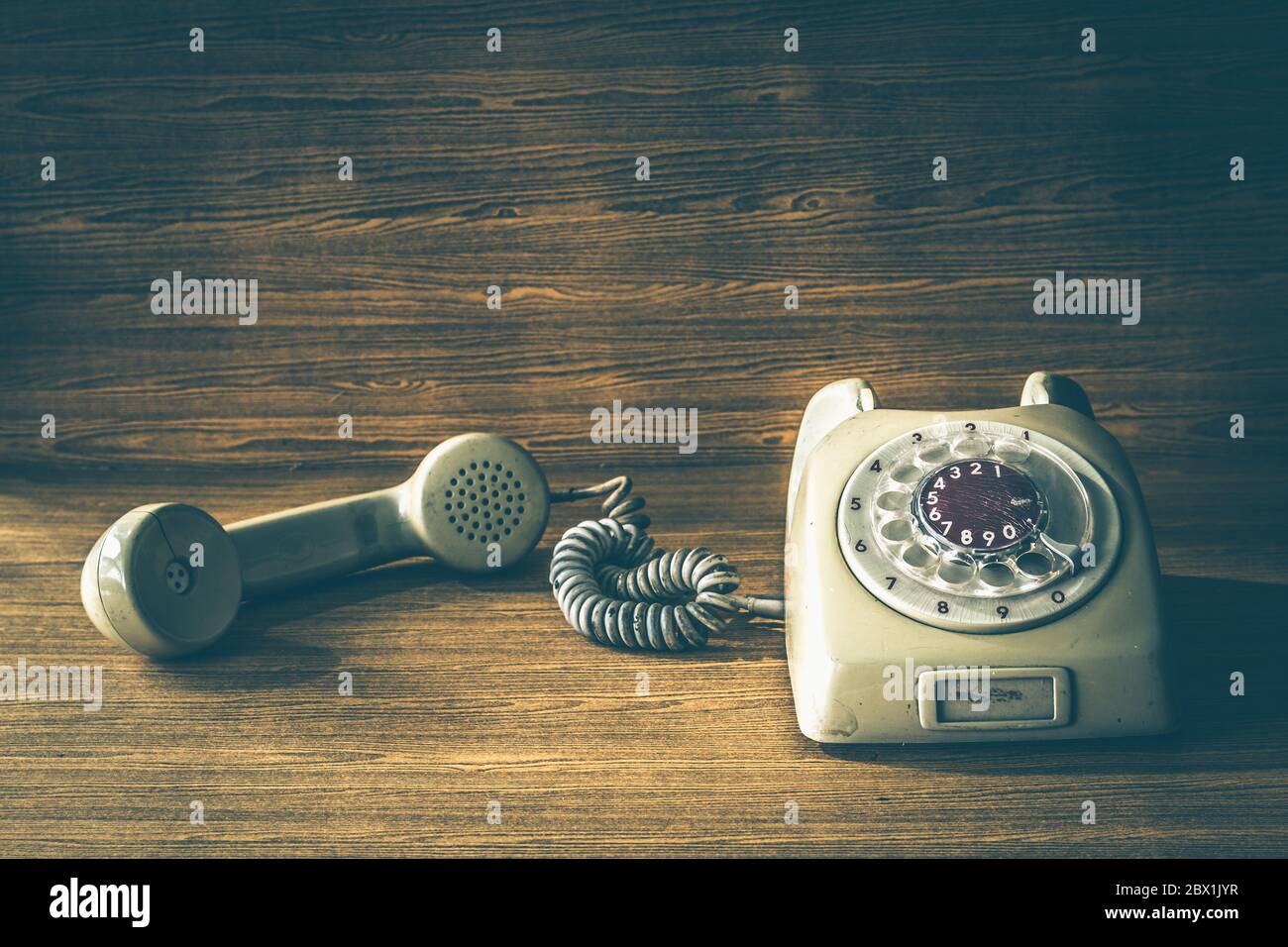 Old telephone on wooden table background. Vintage tone Stock Photo - Alamy