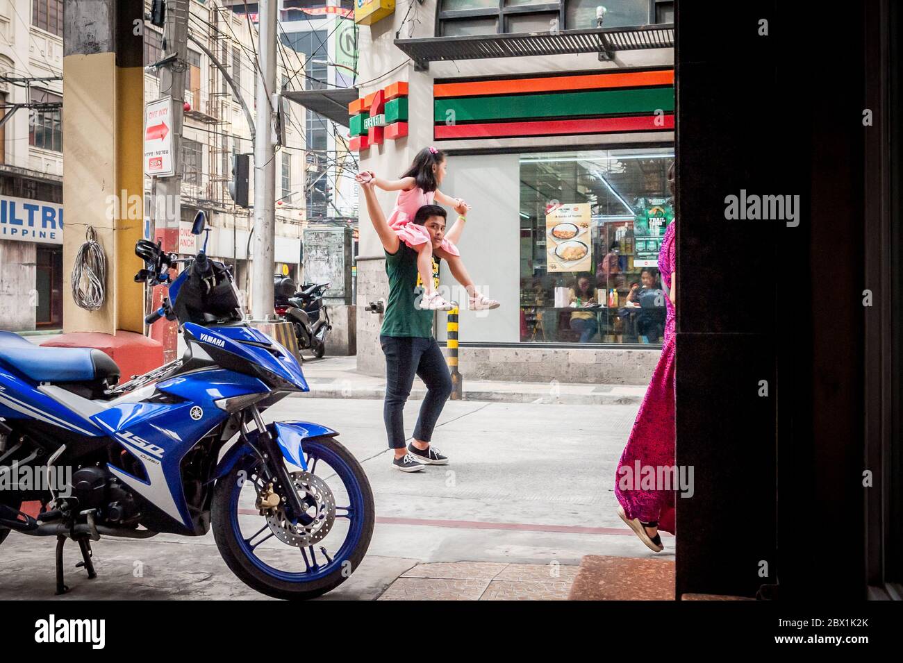 A dad plays with his daughter walking under the  Filipino Friendship Arch in the Binondo District, China Town, Manila, The Philippines. Stock Photo