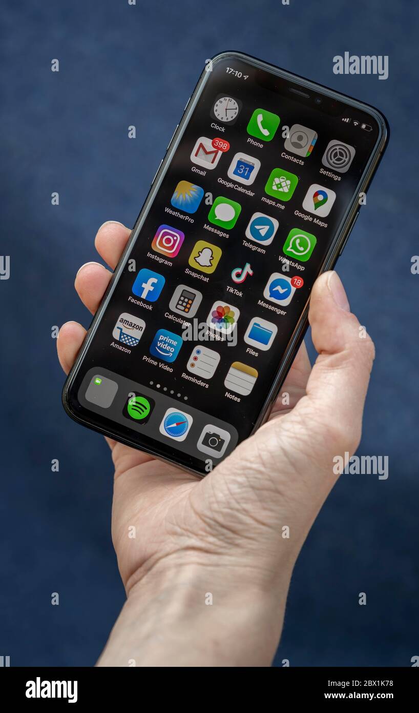 Hand holds iPhone, Smartphone, display with different apps, Germany Stock Photo