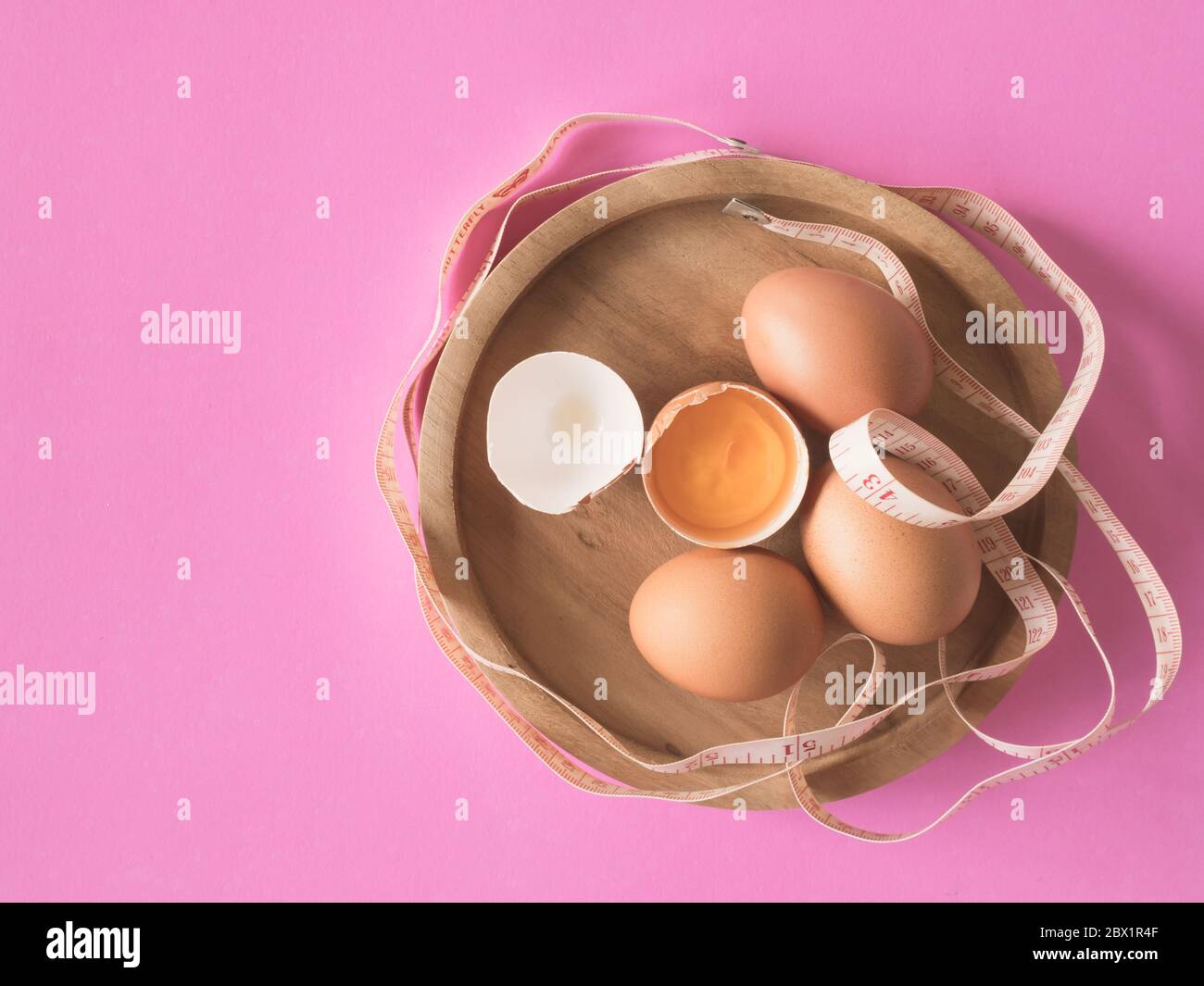 https://c8.alamy.com/comp/2BX1R4F/eggs-with-tape-measure-on-pink-background-2BX1R4F.jpg