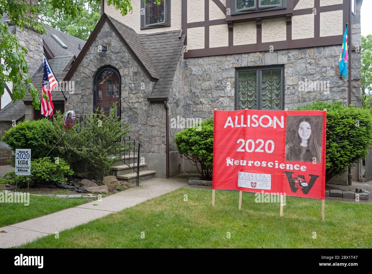 In lieu of an actual graduation, a family celebrates their college graduate with congratulatory signs in their front yard. In Flushing, Queens, NYC. Stock Photo