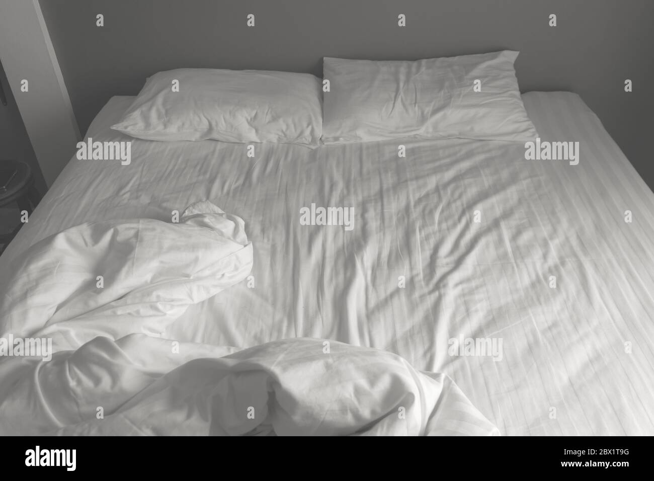 Messy white bedding sheets and pillows. black and white tone Stock Photo