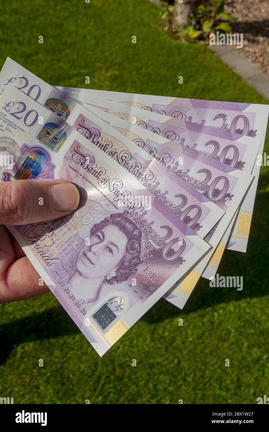 Close up of man person holding new £20 twenty pound banknotes notes cash money  England UK United Kingdom GB Great Britain Stock Photo