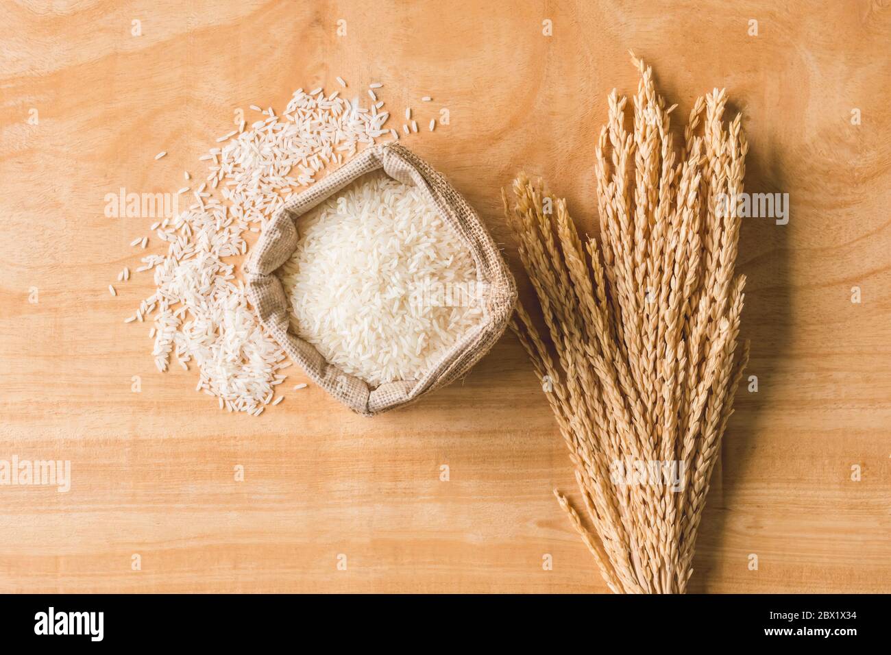 Row Rice Image Top view of Raw rice grain and dry rice plant on wooden table ...
