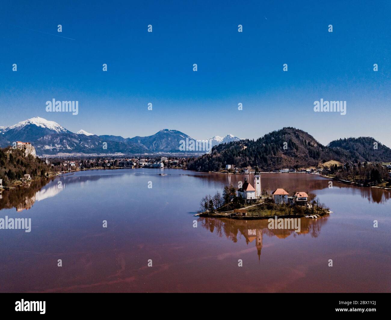 Famous lake red color and island Bled (Blejsko jezero) in Slovenia. Beautiful alpine mountain lake with Pilgrimage Church of the Assumption of Maria a Stock Photo