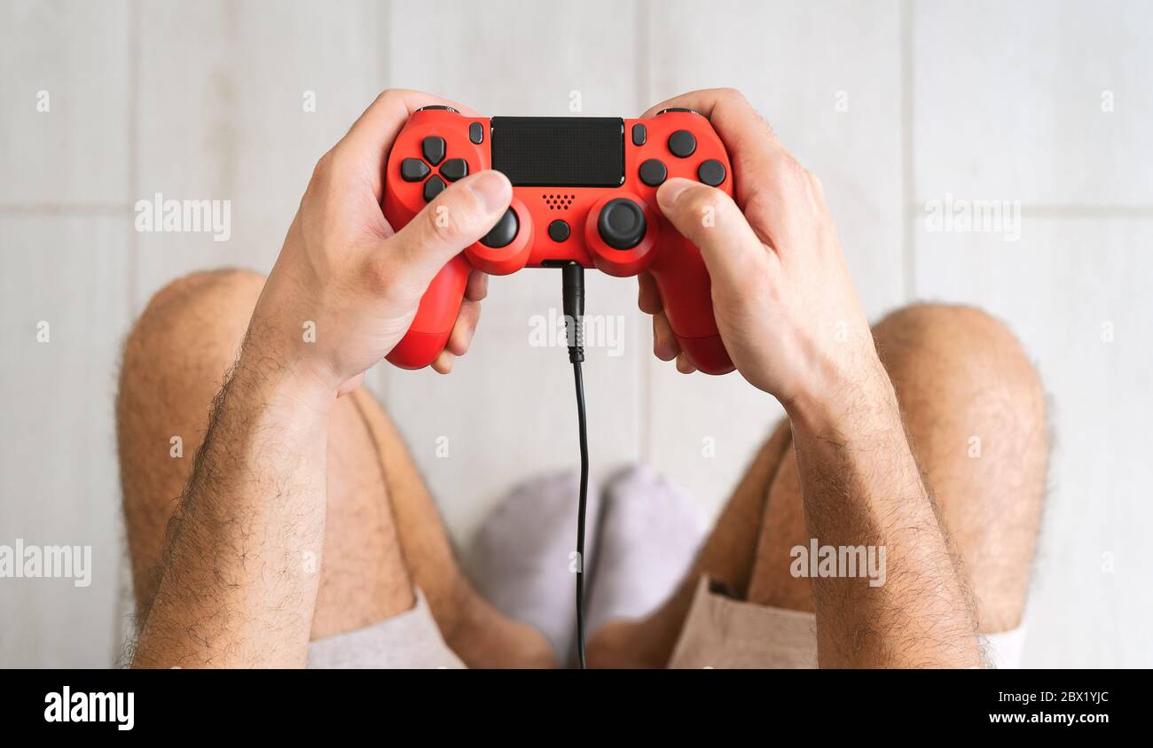 Young man playing online video games - Close up male hands gamer having fun on new technology console Stock Photo