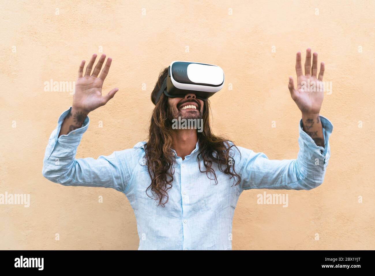Happy man using virtual reality headset outdoor - Trendy guy having fun with innovated vr googles technology Stock Photo