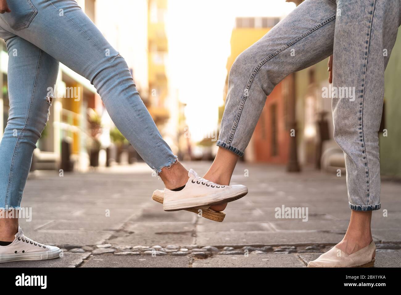 Young friends doing new social distancing greetings with foots for preventing corona virus outbreak - Physical distance and safety greetings concept Stock Photo