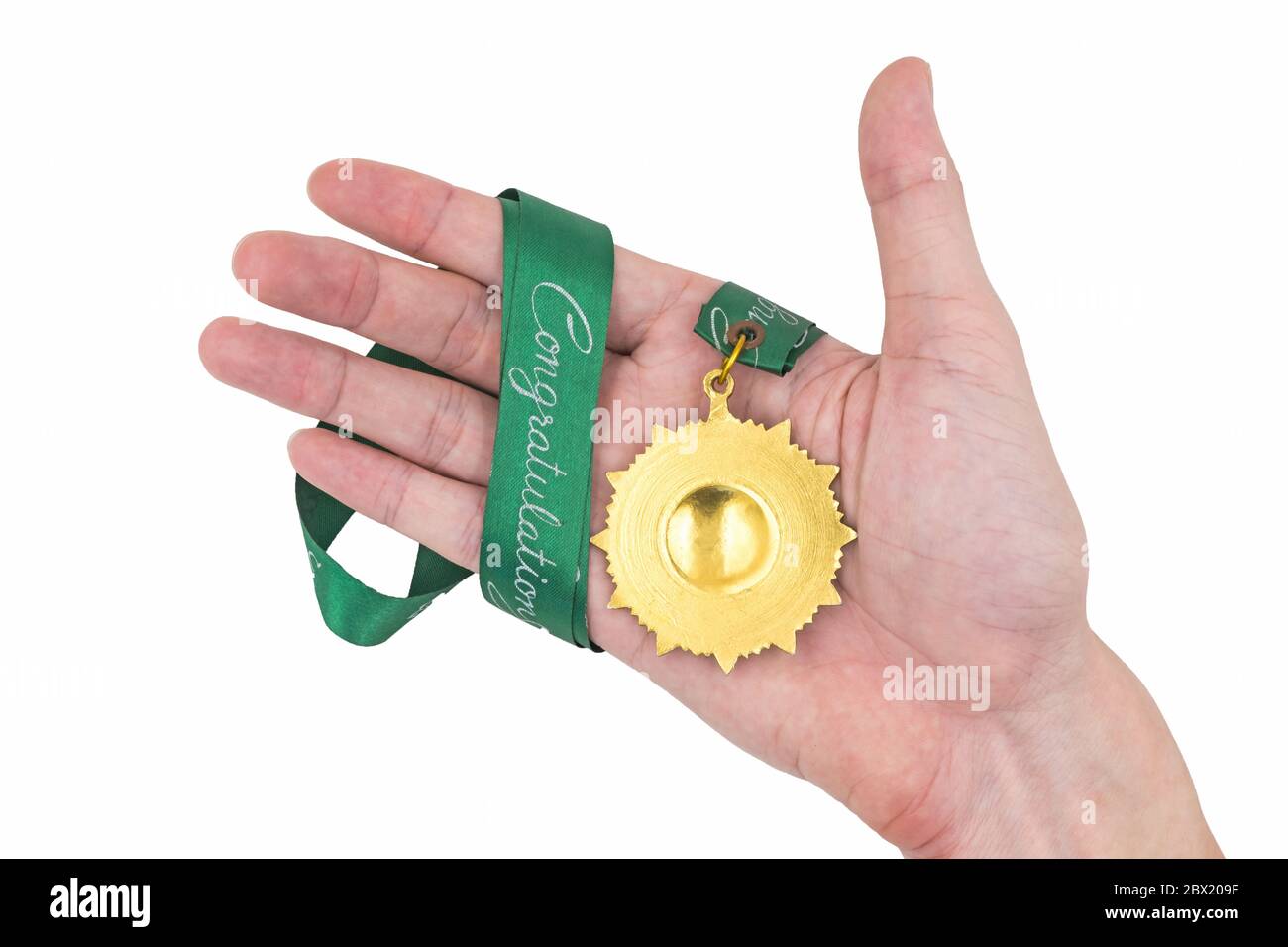 Hand holding Gold medal with green ribbon on white background Stock Photo