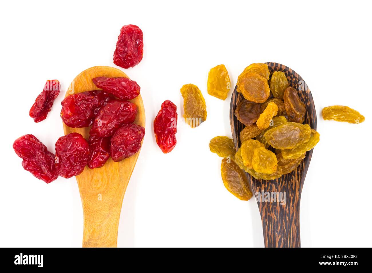 Yellow raisins and Dried Tomatoes on wooden spoons. Stock Photo