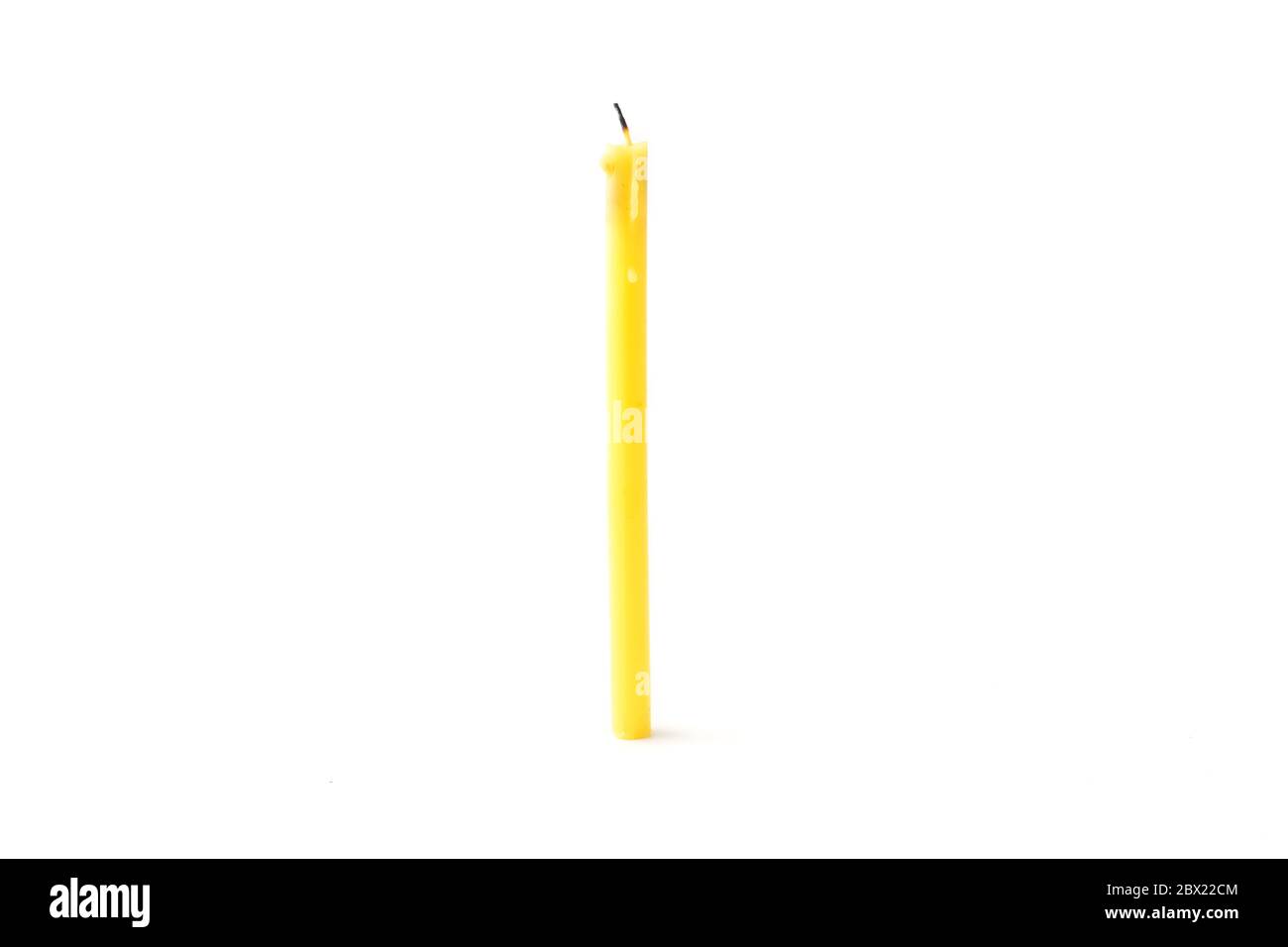 Tall yellow wax candle on a white background Stock Photo Alamy