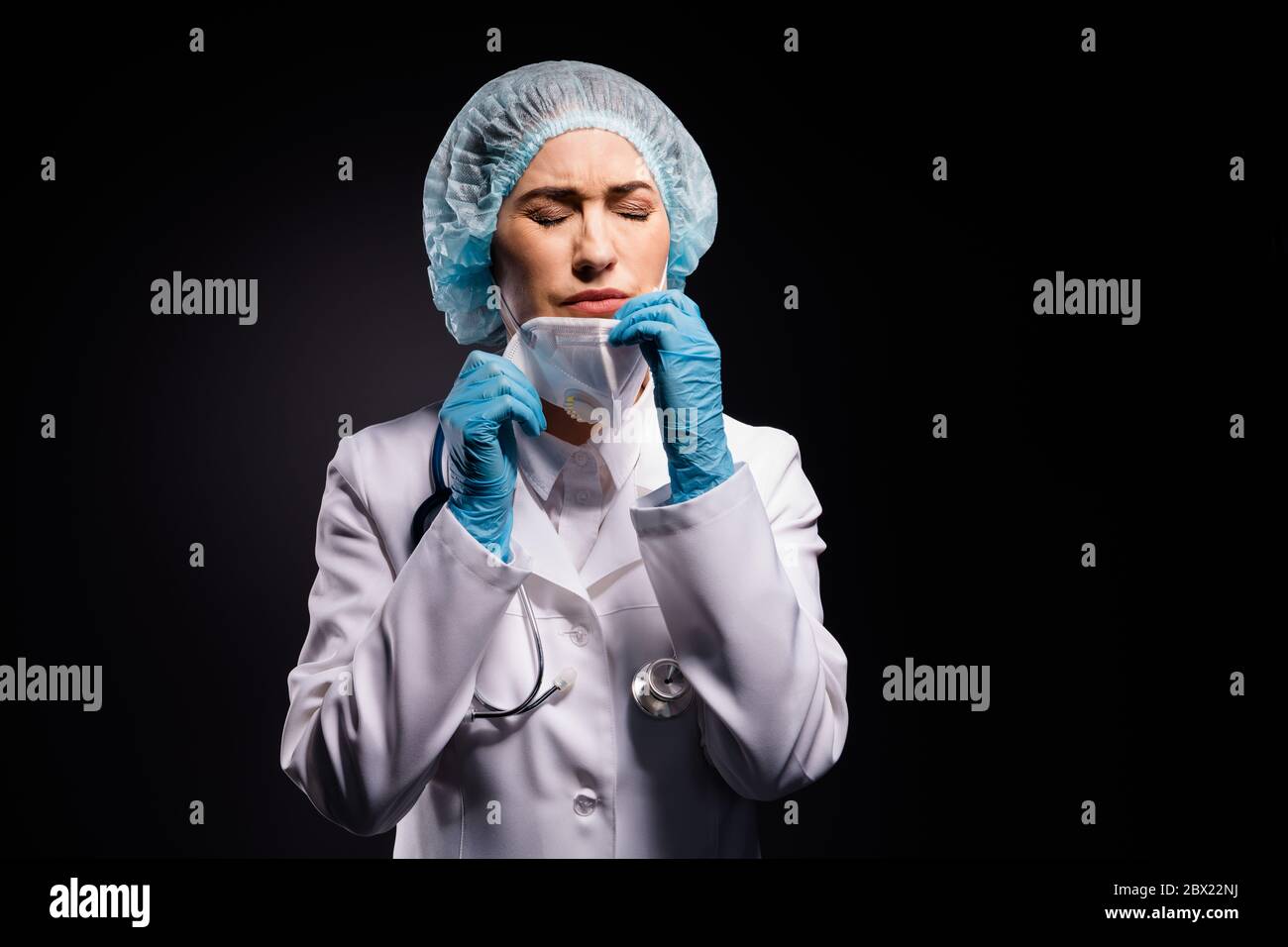 Photo of tired exhausted crying lady doc taking off protective mask after last late operation breathing fresh air wear gloves lab white coat surgical Stock Photo