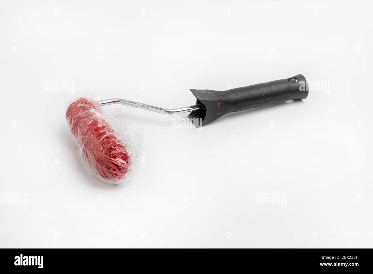 A small paint roller wrapped in cling film to keep it moist Stock Photo