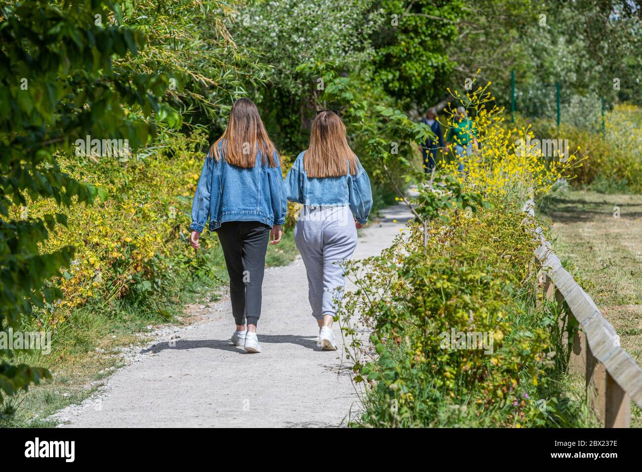 Two young women taking an exercise walk during the coronavirus pandemic. Stock Photo