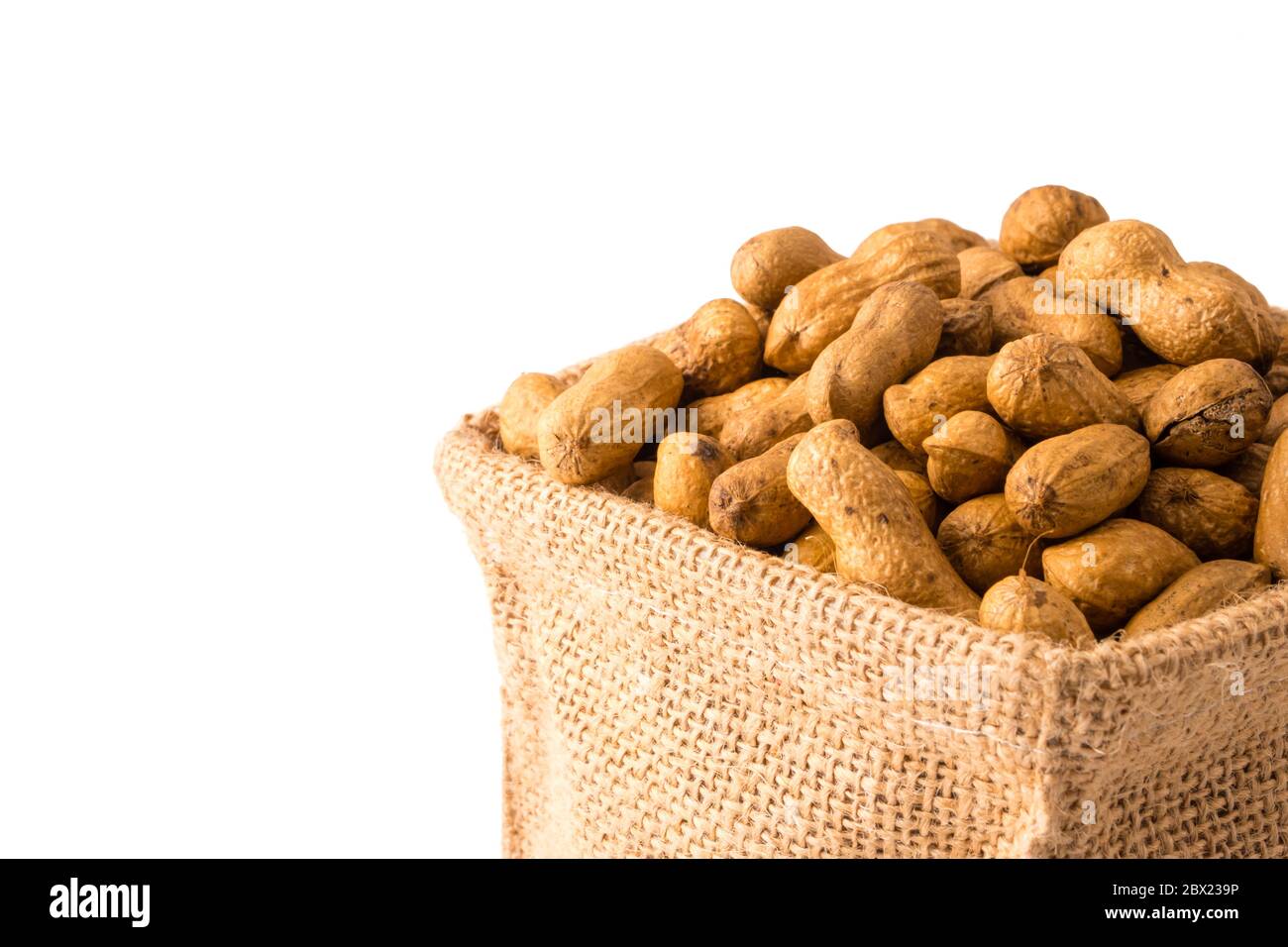 Peanuts in burlap bag on white background. Stock Photo