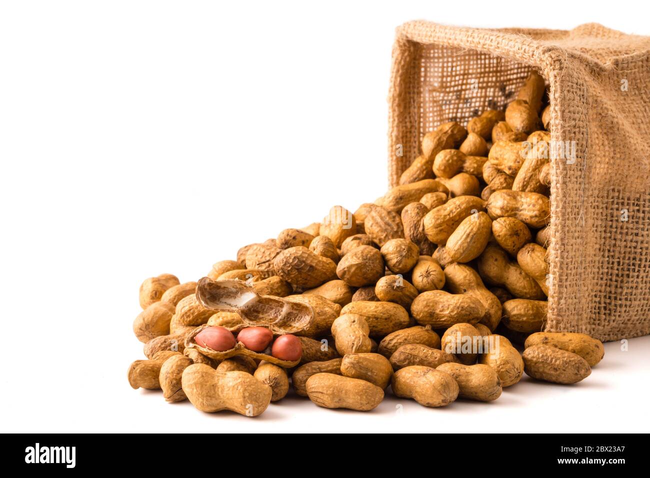 Peanuts in burlap bag on white background. Stock Photo