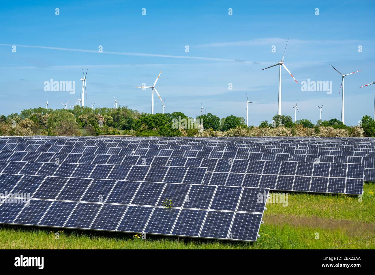 Solar panels with wind wheels in the back seen in Germany Stock Photo
