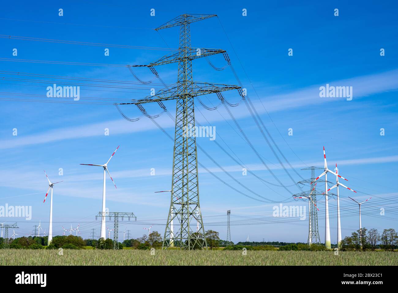 Overhead power lines and wind turbines seen in Germany Stock Photo