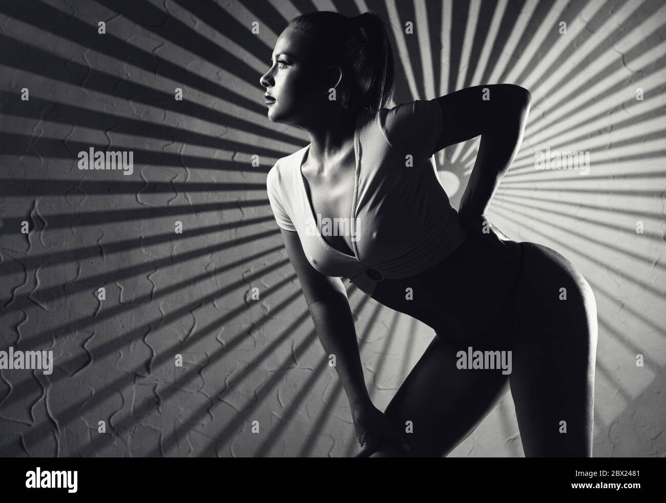 Young beautiful woman with shadows on face. Black and white fashion art studio Stock Photo