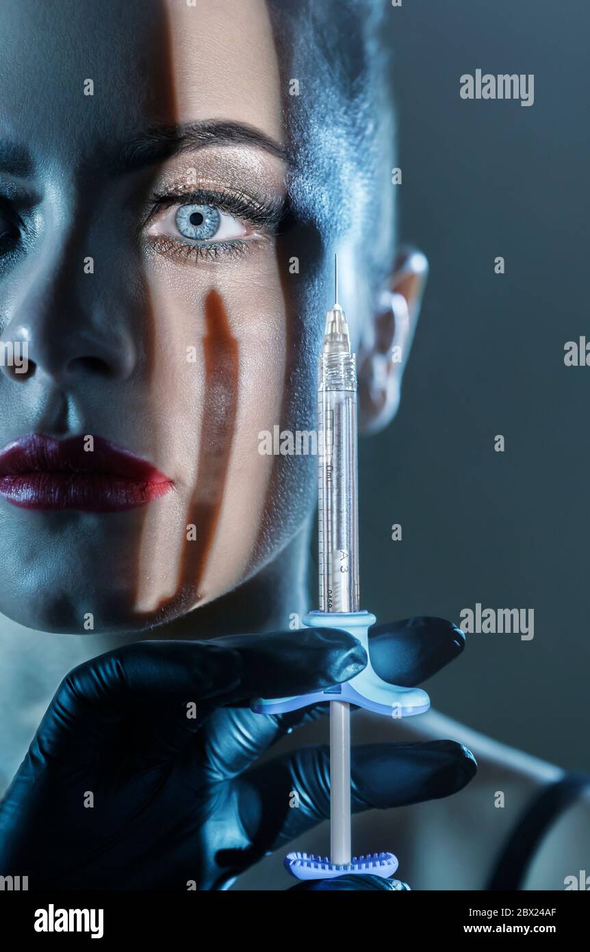 Cosmetology. Portrait of beautiful young woman face with syringe. Beauty treatment. Cosmetic or botox injections Stock Photo