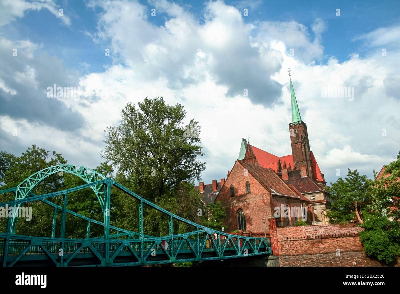 Church of Saints Peter and Paul and the Most Tumski bridge with its typical red bricks. Also called kosciol sw piotra i sw pawla we wroclawiu, it is a Stock Photo