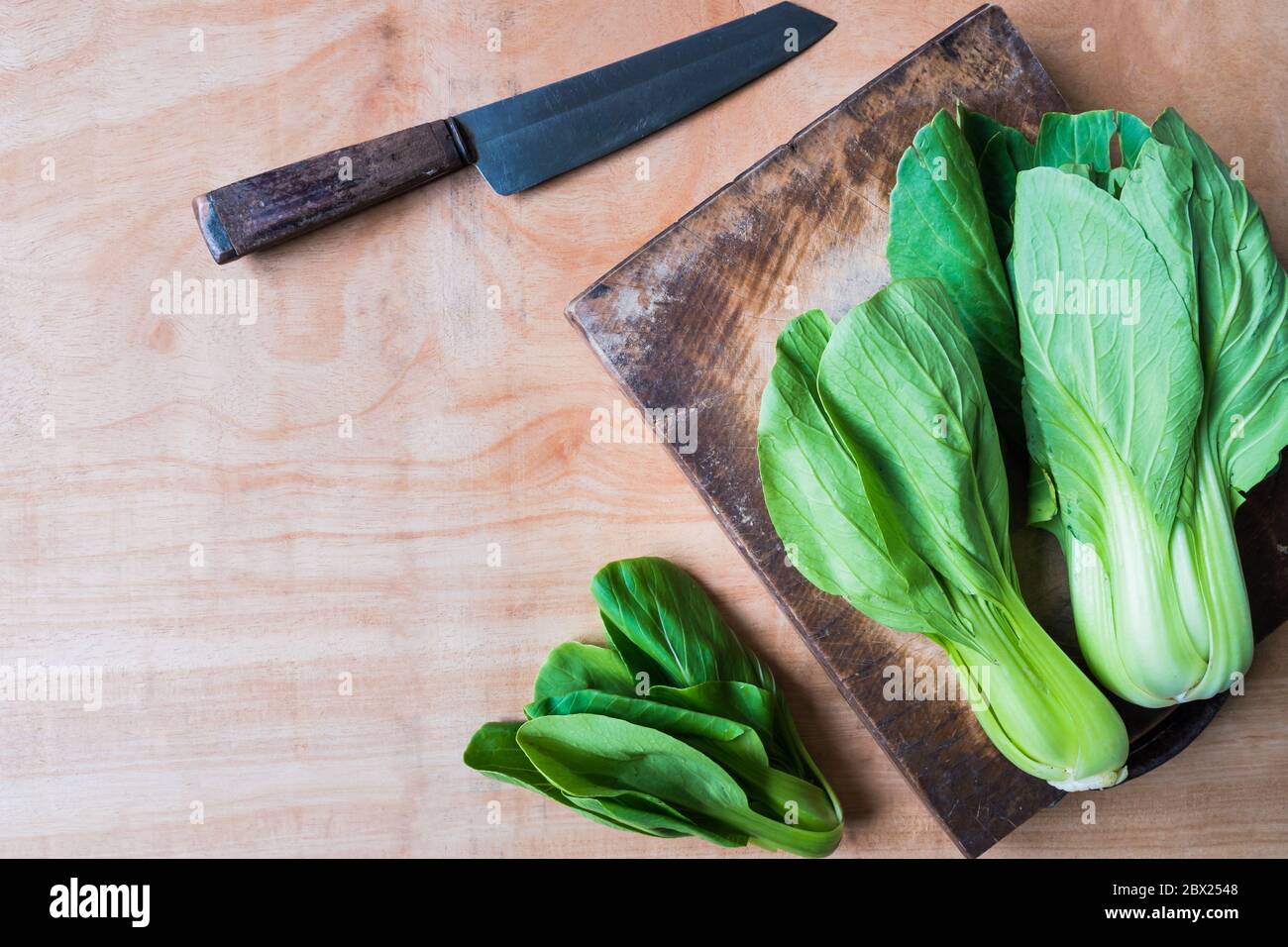 Top view of Bok choy (chinese cabbage) on wooden chopping block with