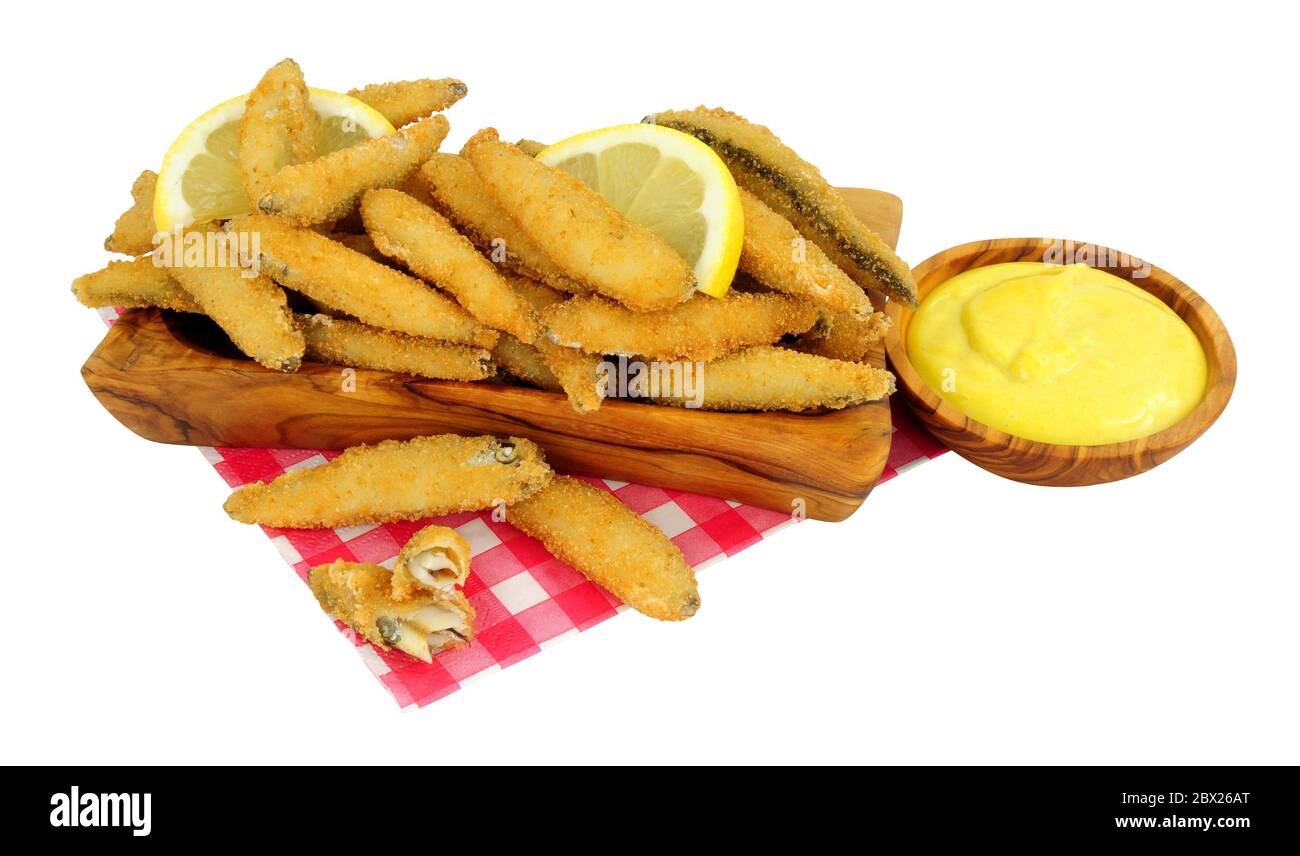 Fried bread crumb covered whitebait fish with mayonnaise dip in an olive wood dish isolated on a white background Stock Photo