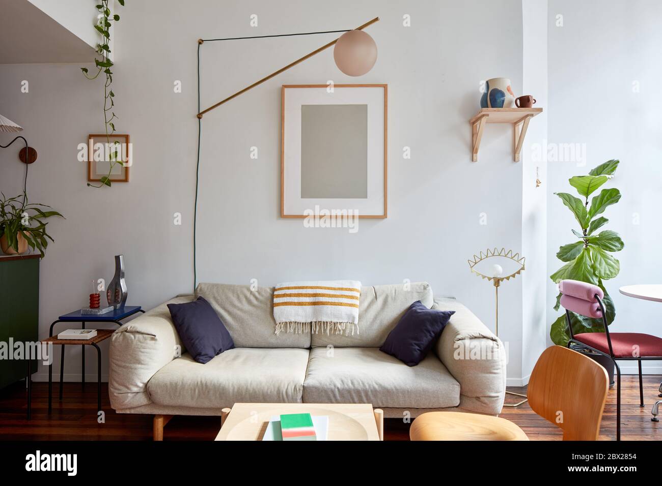 Couch and swinging lamp in loft apartment living room Stock Photo