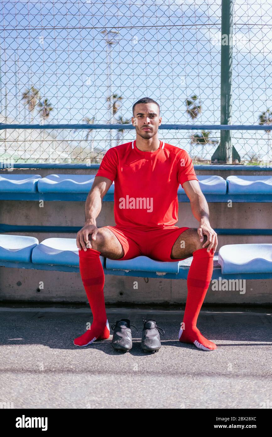 Portrait of African American male soccer player sitting on bench Stock Photo