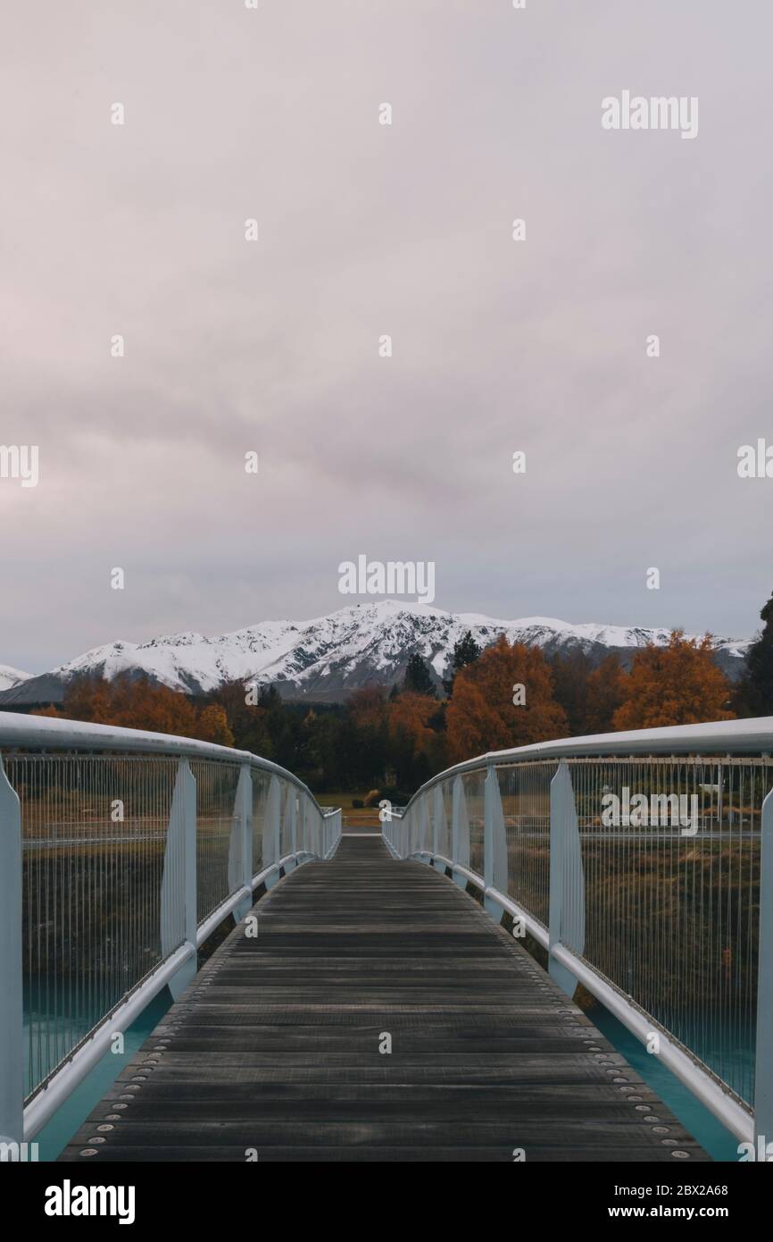 Bridge over Lake Tekapo with the Southern Alps mountains in the background. Stock Photo