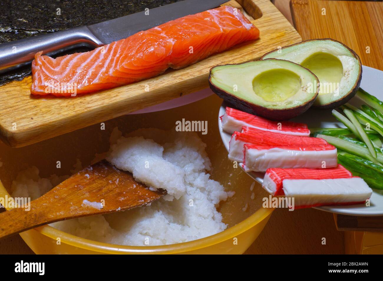 Products for sushi: rice, salmon, surimi crab sticks, nori kelp, cucumbers and avocado. Do it yourself. Stock Photo