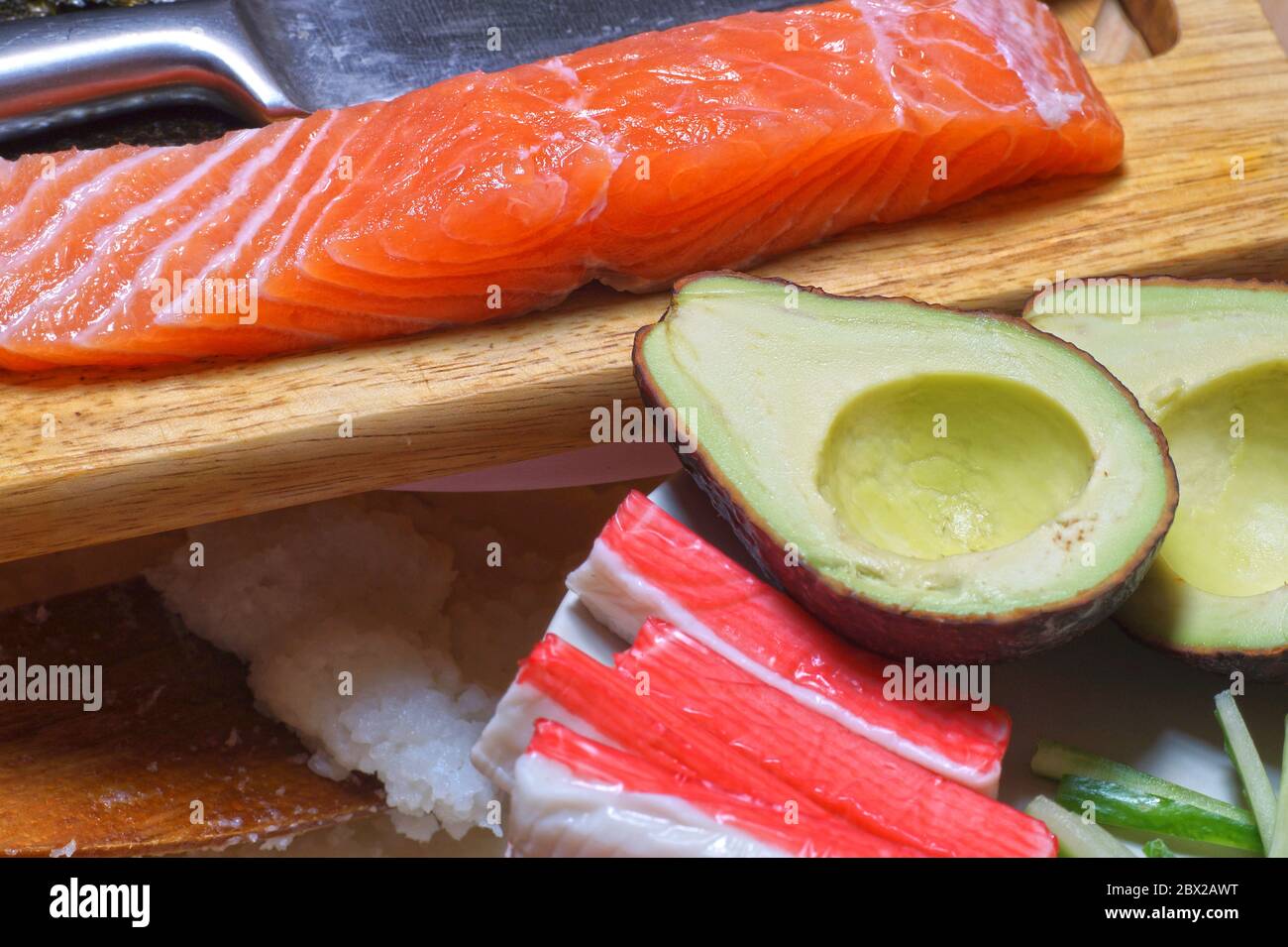 Do it yourself. Products for sushi: rice, salmon, surimi crab sticks, nori kelp, cucumbers and avocado. Stock Photo
