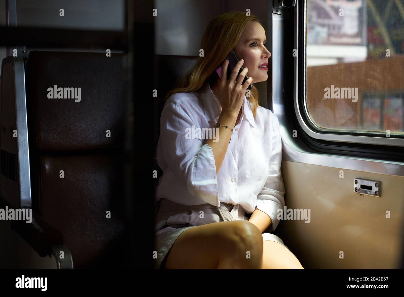 A woman using a smart phone on a train Stock Photo