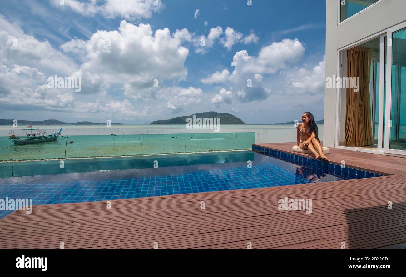 beautiful woman sitting by the pool at luxury villa in Phuket Stock Photo