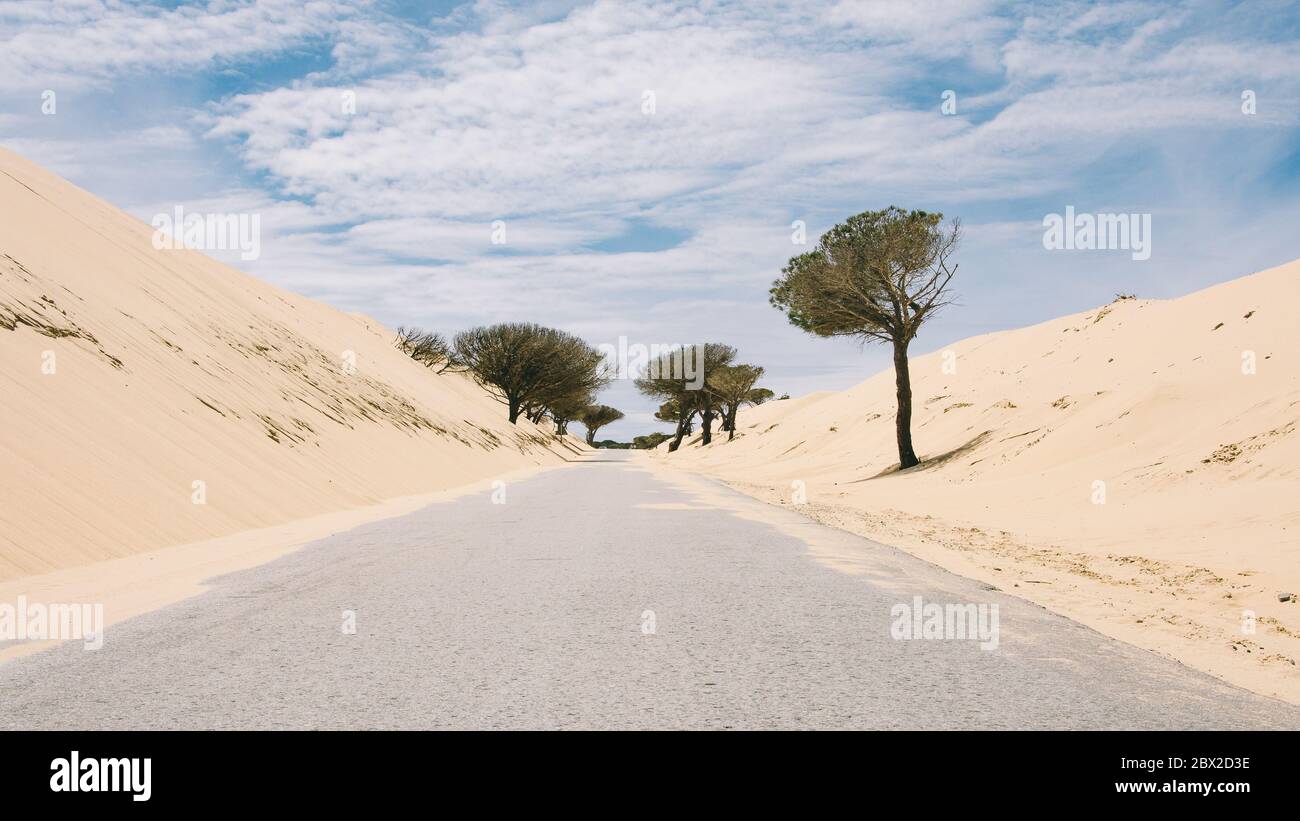 a road covered with sand that the wind brings to the road in Tarifa, south of Spain, famous place to enjoy watersports Stock Photo